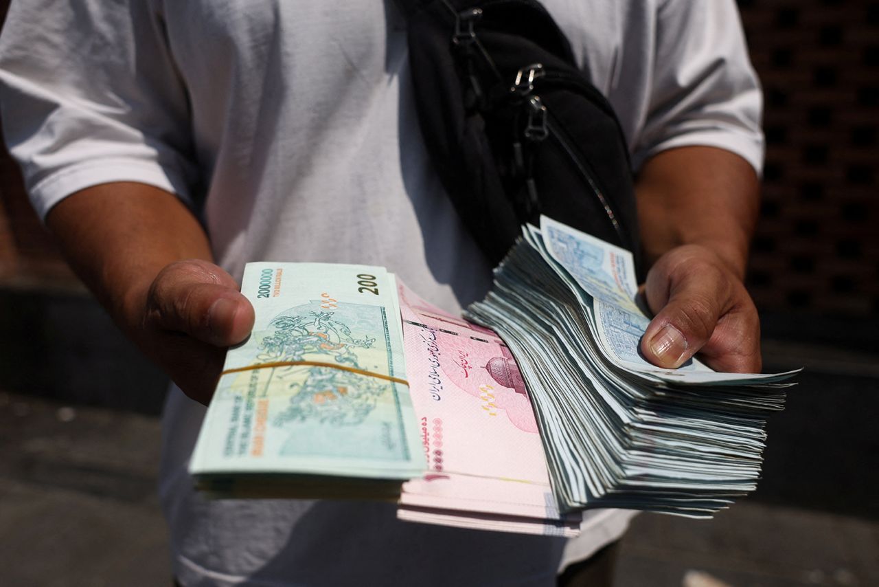 A currency dealer holds Iranian Rial in the Grand Bazaar in Tehran, Iran, on August 17.