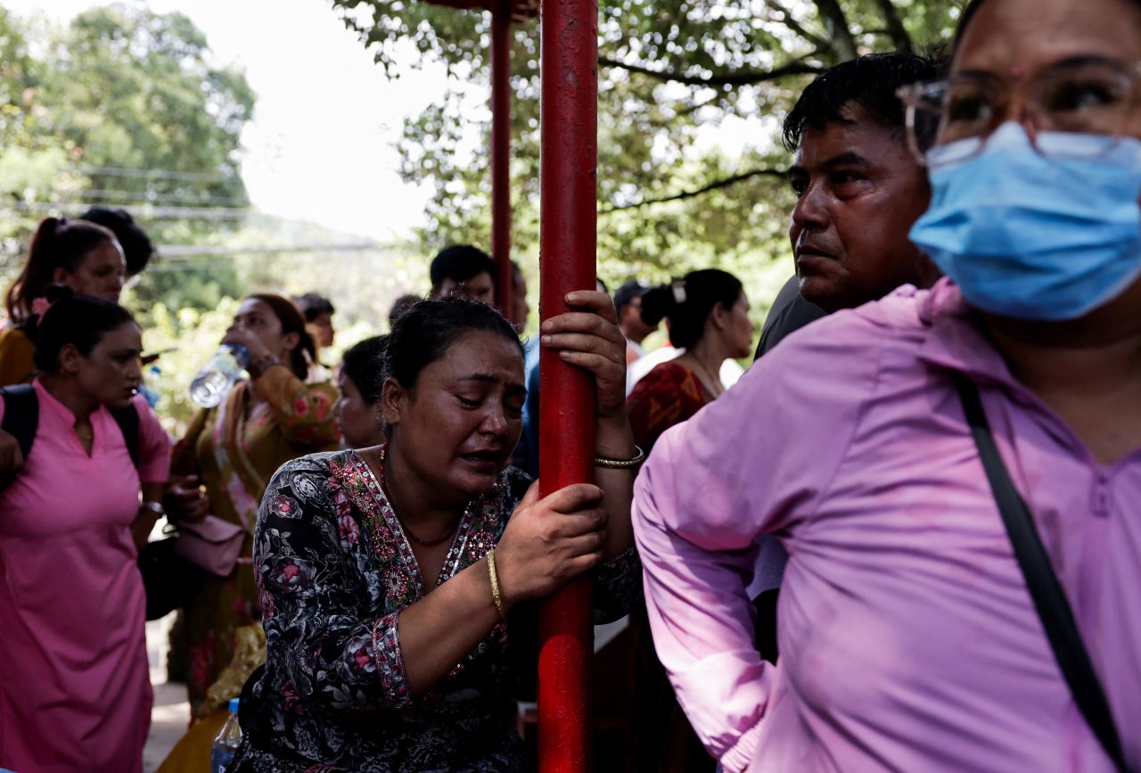 A woman cries as she waits for updates on whereabouts of her missing family member, in the aftermath of flash floods, outside the Maithali Barrack, an army training center in Trishuli, Nuwakot district, Nepal, on August 27.