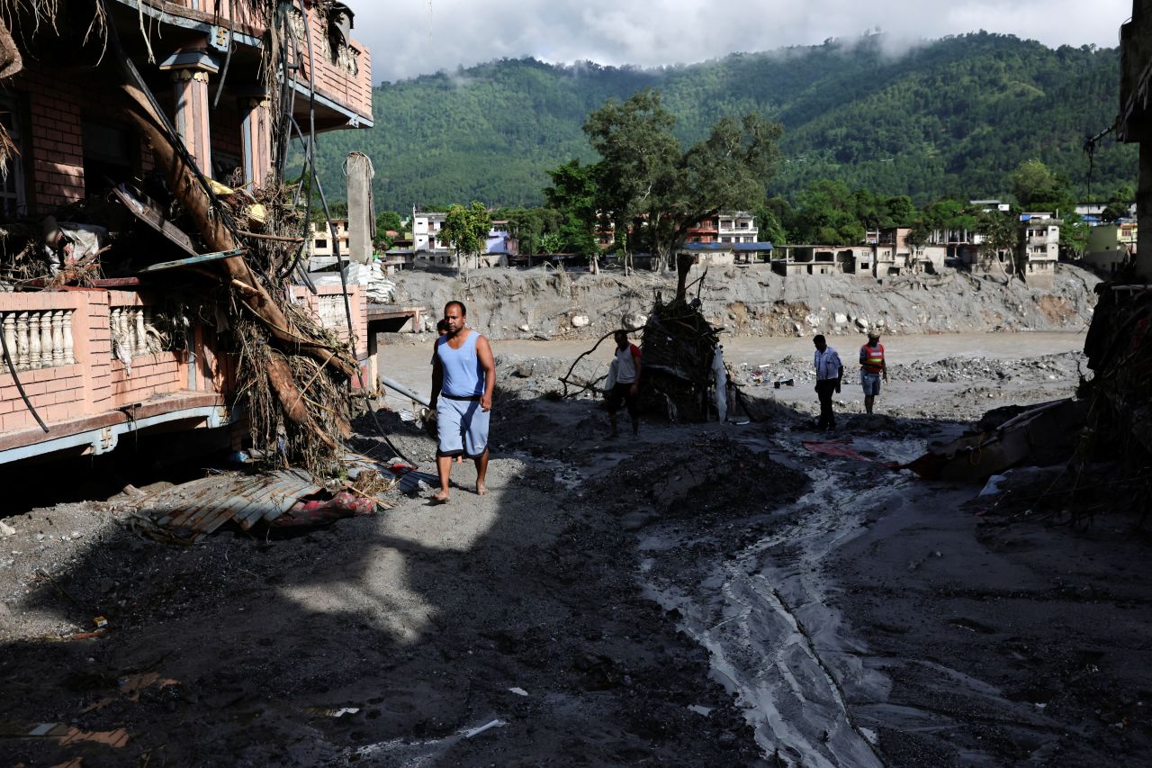 People move through a mud-covered road following flash floods and a mudslide in Trishuli, Nuwakot district, Nepal, on Friday.