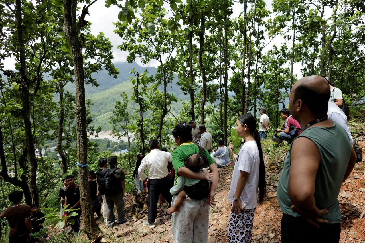 People stand on a hill after reaching high ground following a warning that a lake has broken its banks, two days after flash floods and a mudslide in Trishuli, Nuwakot district, Nepal, on August 28,.