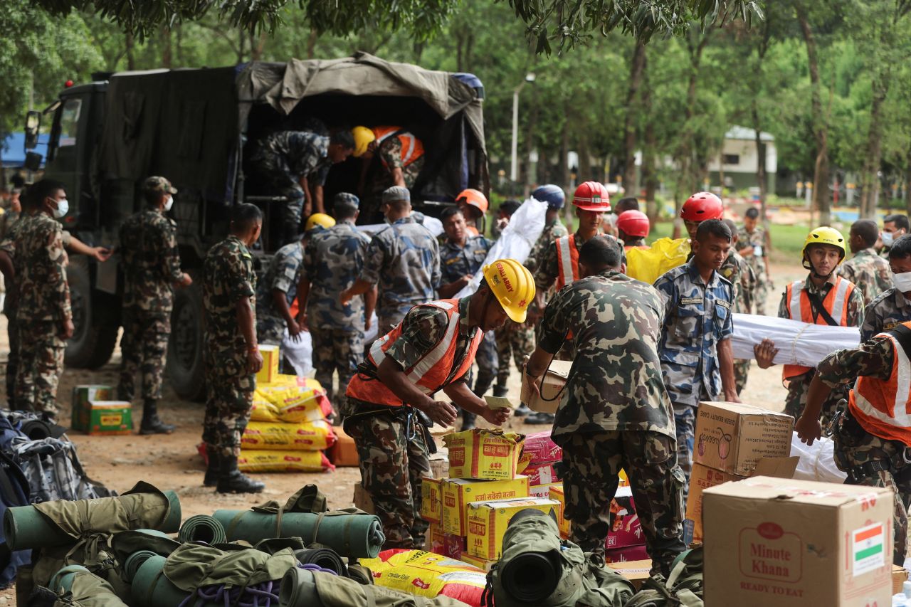 Armed Police Force and army personnel unload relief material from a vehicle at the Maithili Barracks, in Nuwakot district, Nepal, on Monday.