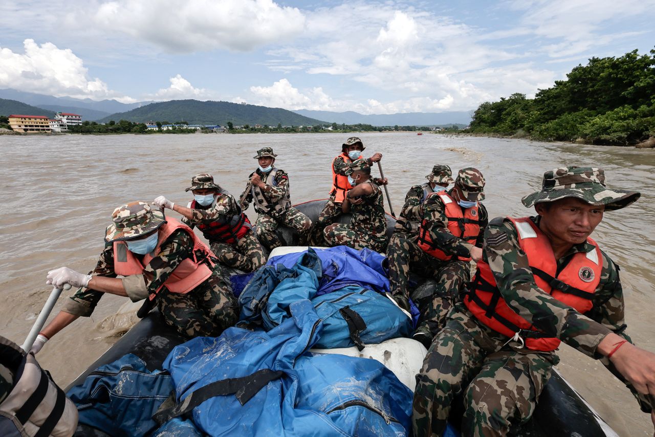 Members of the Nepali Army conduct a search operation on Monday for bodies washed away by flash floods and a mudslide in the Narayani River.