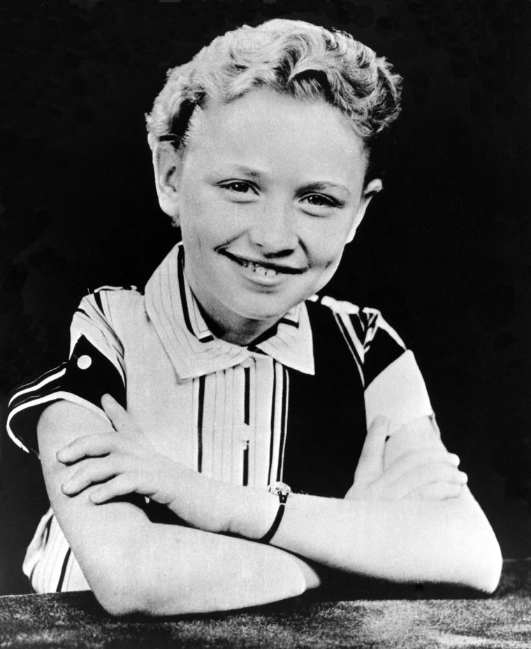 A childhood portrait of Dolly Parton, black and white