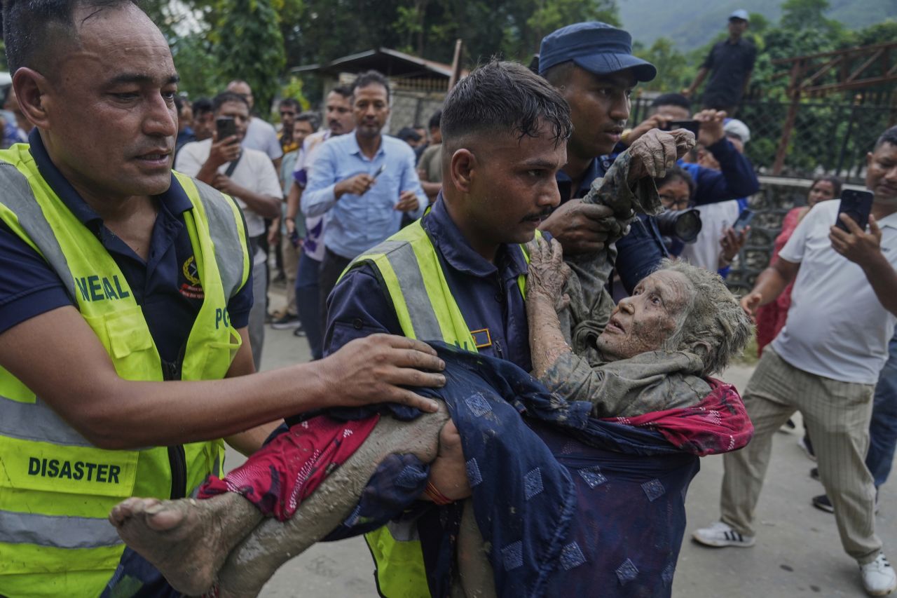 Rescuers carry a victim of flash flooding to safety along the Trishuli River in Nepal's Nuwakot district, Wednesday, Aug. 26.