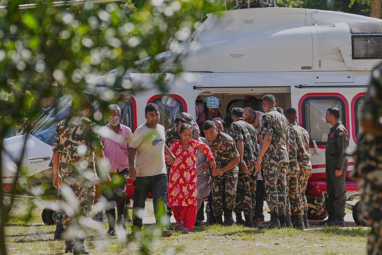 Army soldiers help a family disembark from a helicopter in Nepal on Friday.