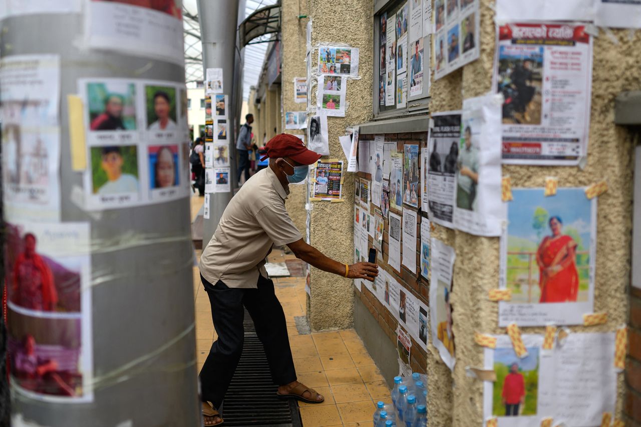 A man looks at photographs of missing persons in the aftermath of flash floods, at the Tribhuvan University Teaching hospital in Kathmandu on Monday.