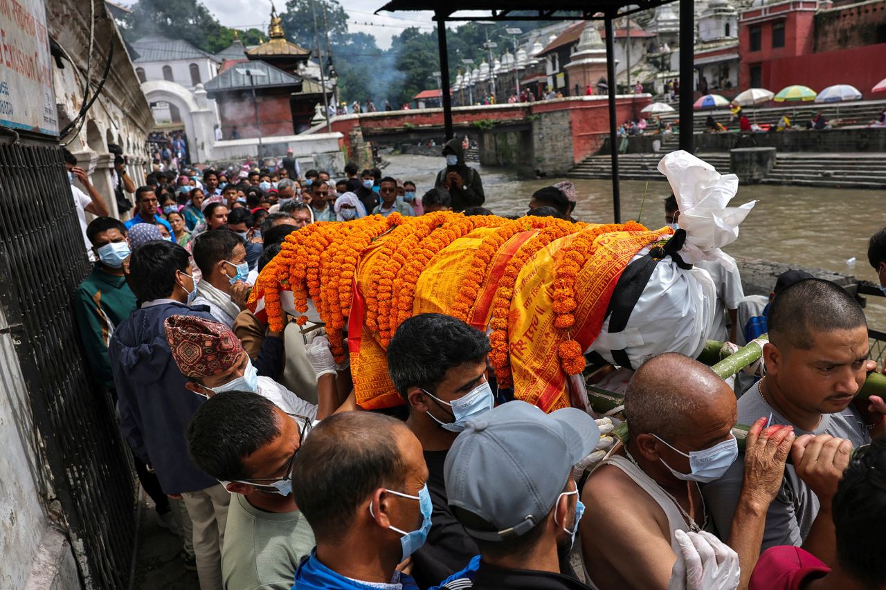 People carry the body of flood victim Nakul Sharma, 36, during his cremation rituals on the premises of Pashupatinath Temple in Kathmandu, Nepal, on Tuesday.