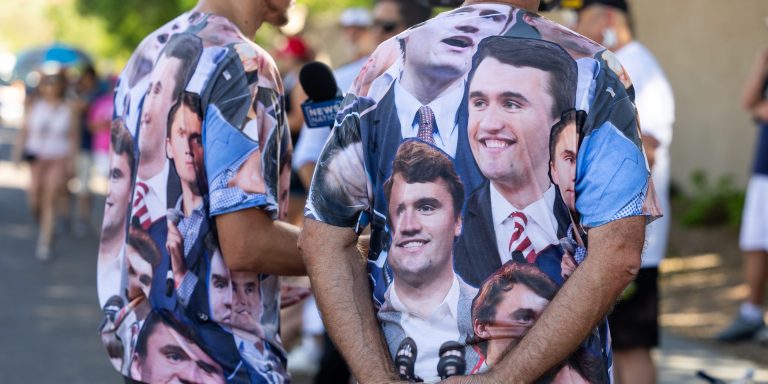 PHOENIX, ARIZONA - SEPTEMBER 20: People wearing T-shirts featuring Charlie Kirk stand outside the Turning Point USA's Phoenix headquarters to commemorate the conservative activist on September 20, 2025 in Phoenix, Arizona. As tens of thousands of people poured into Phoenix this weekend to attend Mr. Kirk's memorial service at the city's N.F.L. stadium on Sunday. (Photo by Qian Weizhong/VCG via Getty Images)